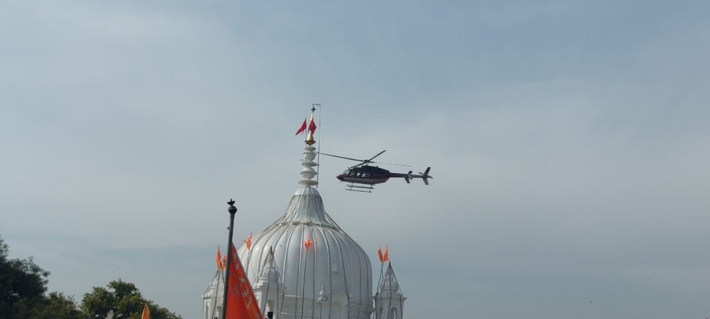 हेलिकॉप्टर से जागेश्वर धाम बांदकपुर में हुई पुष्प वर्षा 