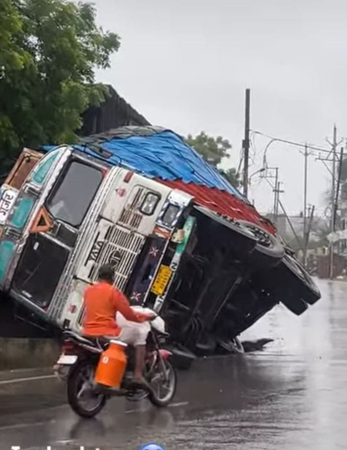 लगातार बारिश से फिर धसकी सड़क, ट्रक पलटा