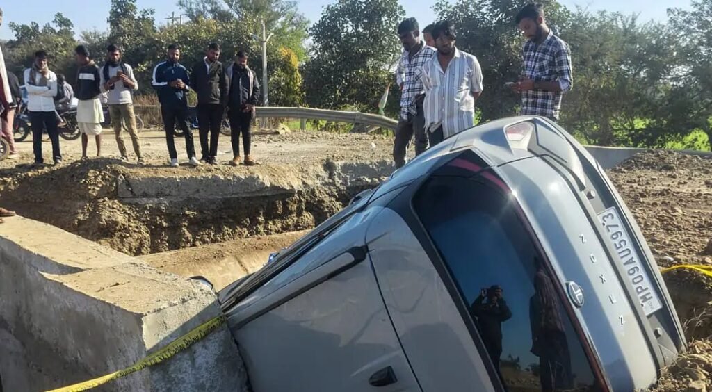 बीच रोड पर विशालकाय गड्ढे में गिरी कार, बाल-बाल बचे कार सवार युवक